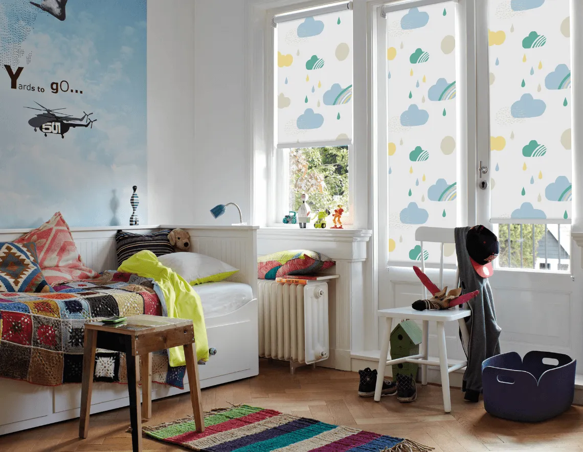 Habitación infantil colorida, con roller estampada diseño con nubes.