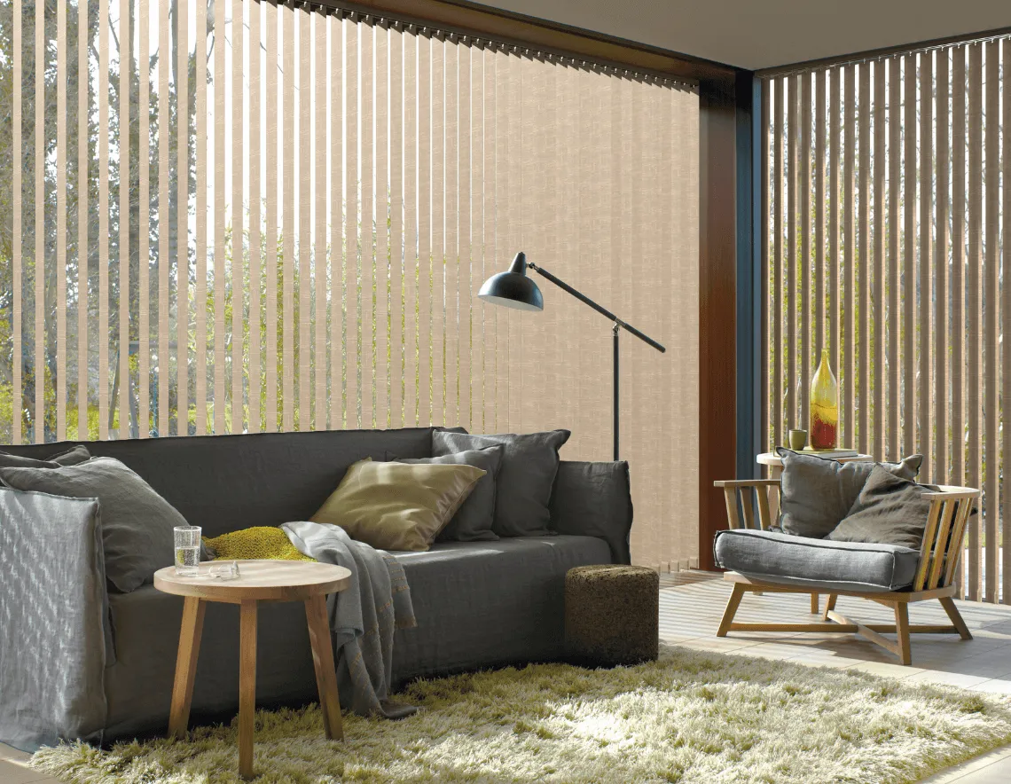 Un living espacioso y contemporáneo con cortinas Verticales y grandes ventanales.