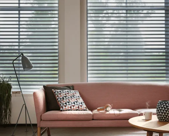 Moderno living con sillón rosa y cortina Nantucket