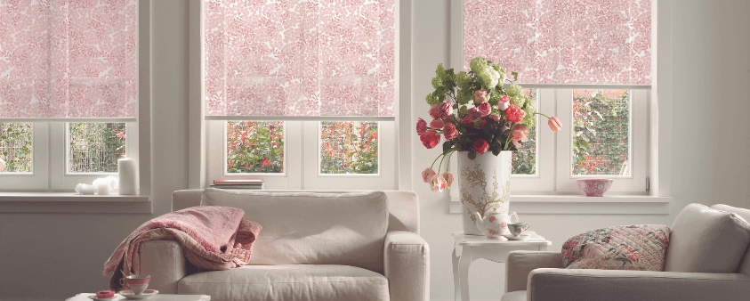 Living estilo romántico con cortina Roller en tela estampadas en tonos blancos y rosados.